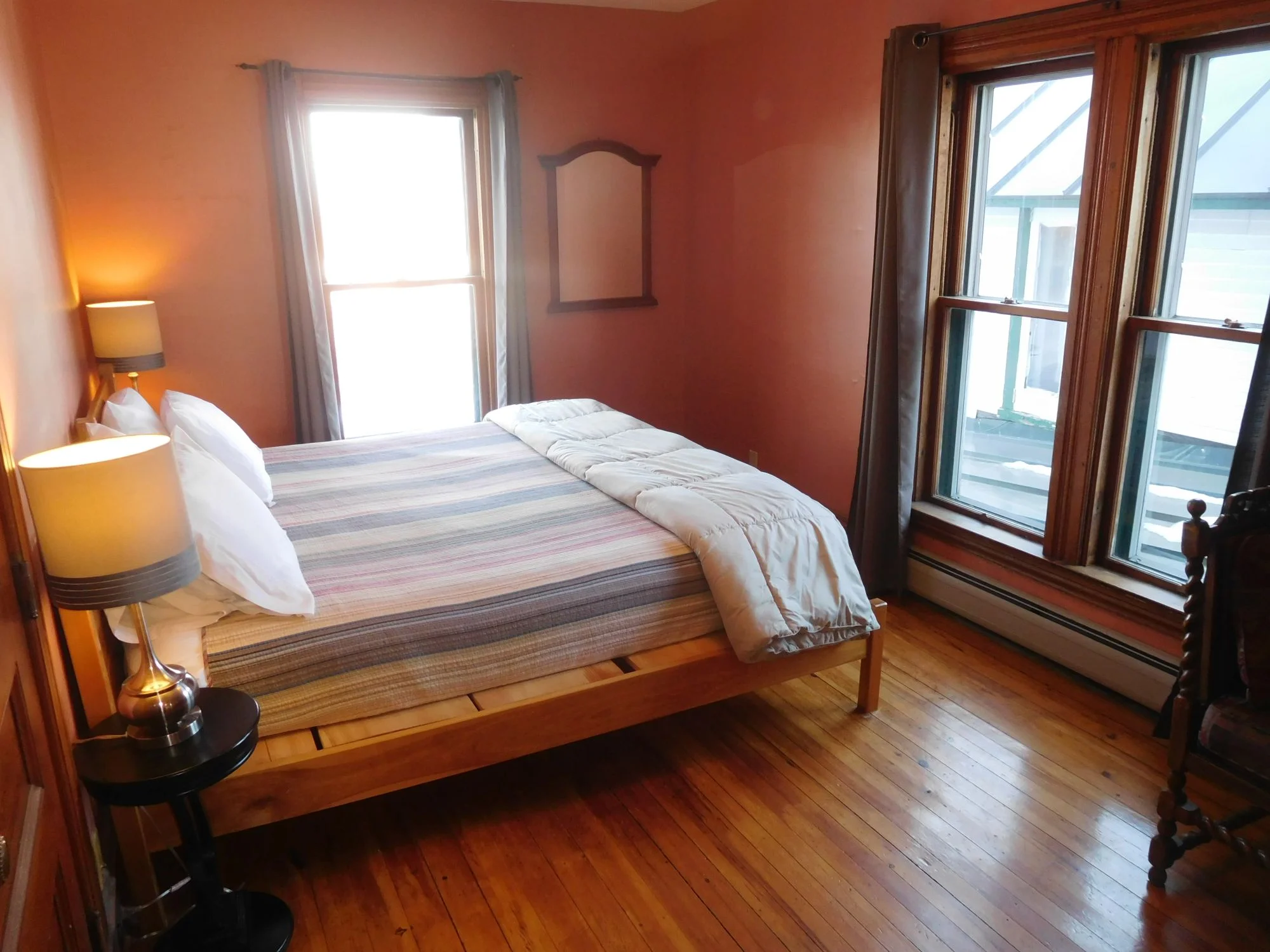 Master bedroom, handmade king bed, west windows facing the lake, sunset.