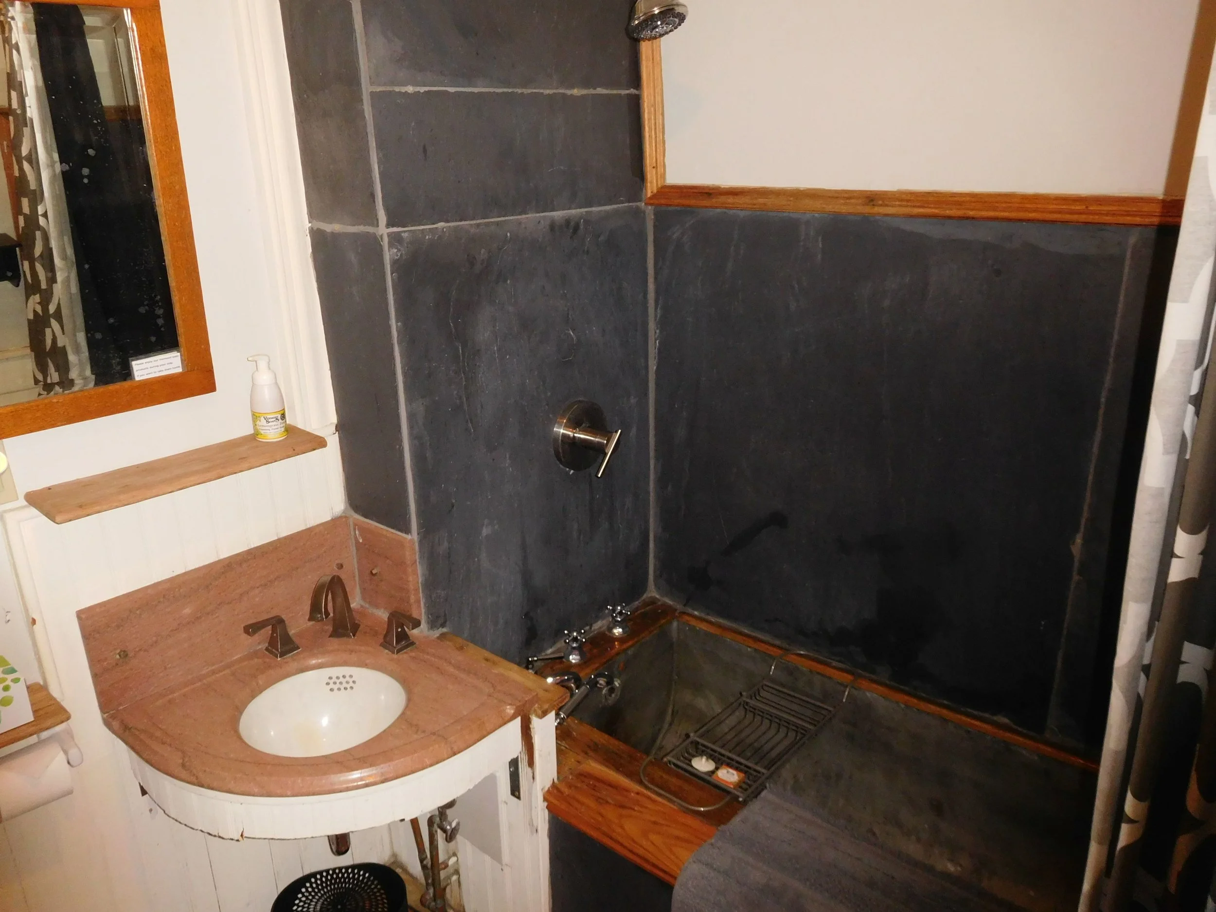 Original tin soaking tub, marble sink, re-purposed slate slab walls