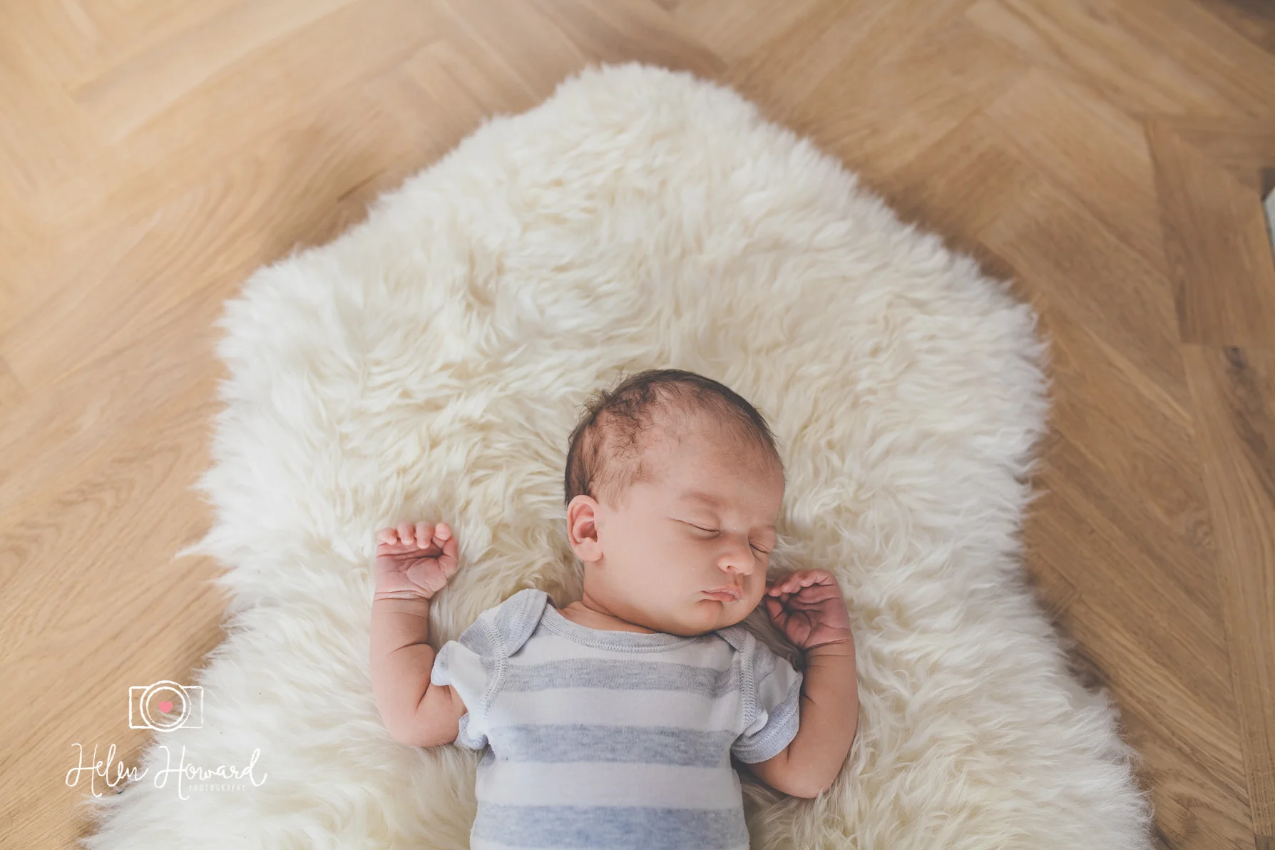 Sleeping newborn baby girl on a sheepskin rug