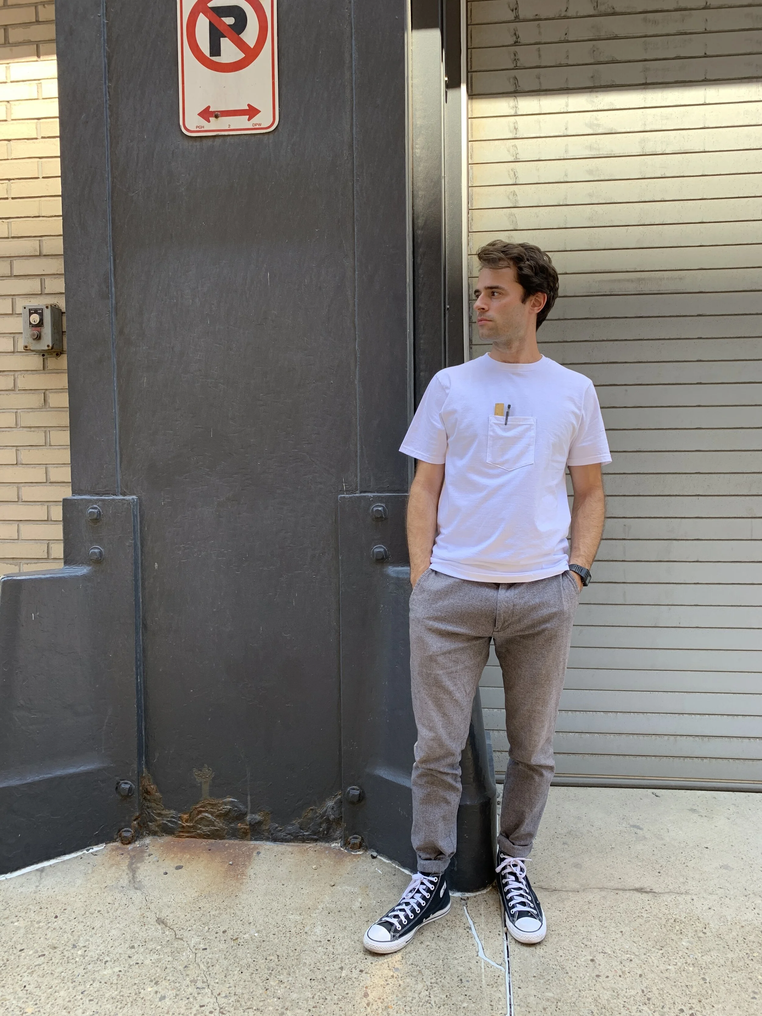 A t-shirt with a pocket in the center of the shirt. A center pocket tee. Worn by a model.