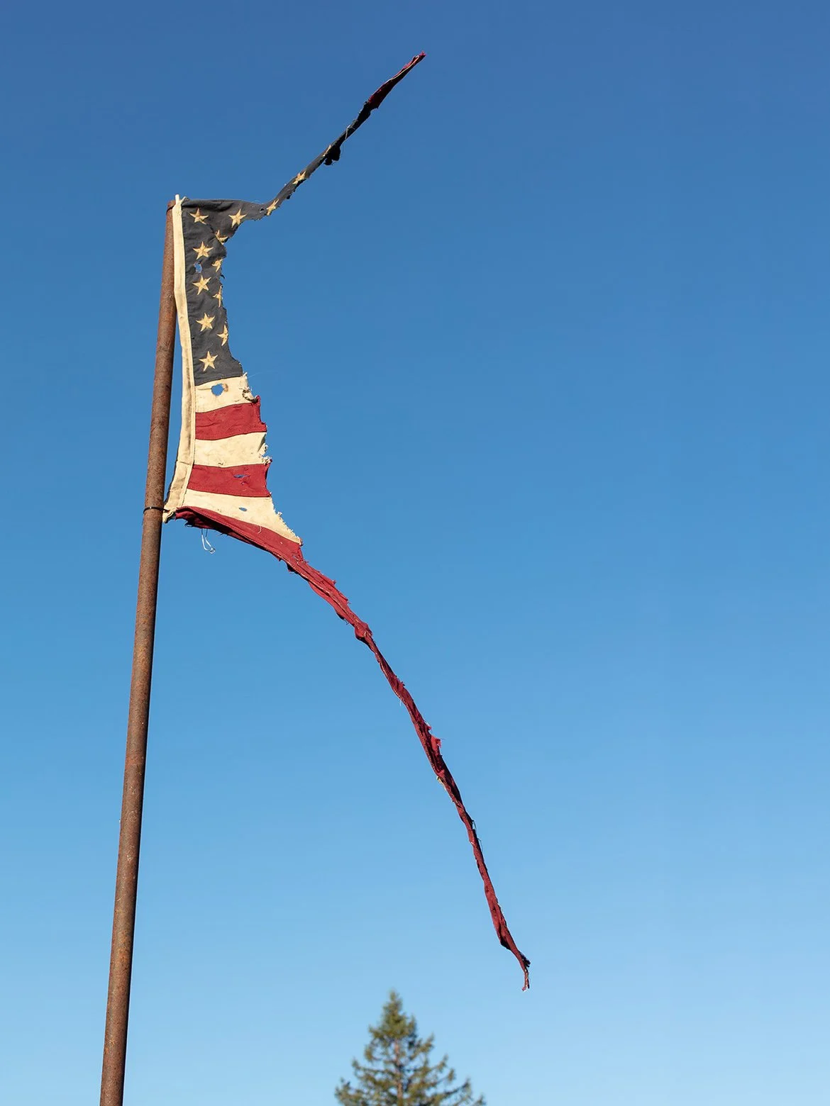 K.K.K-Blam!
(2026) Cotton flag, starch, wire and pole, 36”x60”

“While deconstructing this flag, something that my mother use to tell me while growing up, kept popping up in my mind: ‘You have to be careful, we’re in their country.’ ”
