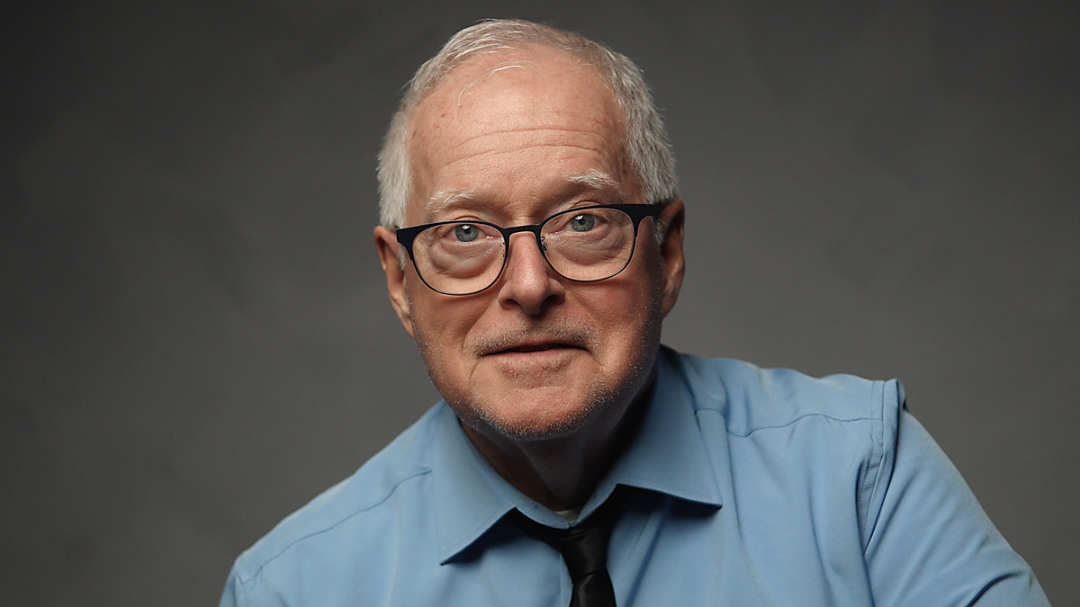 Geoff Edwards looks into the camera lens and smiles as he ends an audition session.