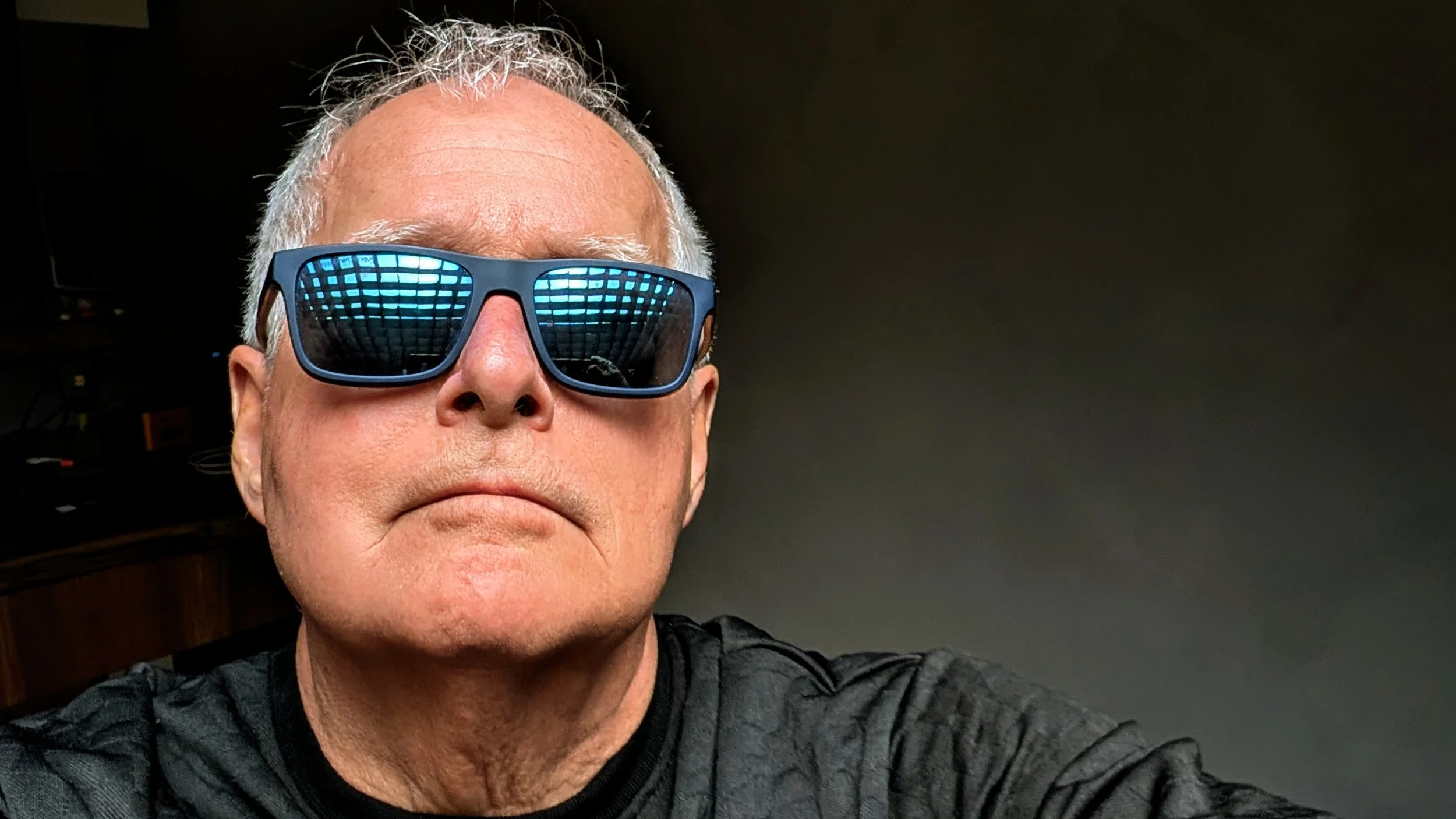 Geoff wearing reflective sun glasses, he's in his studio