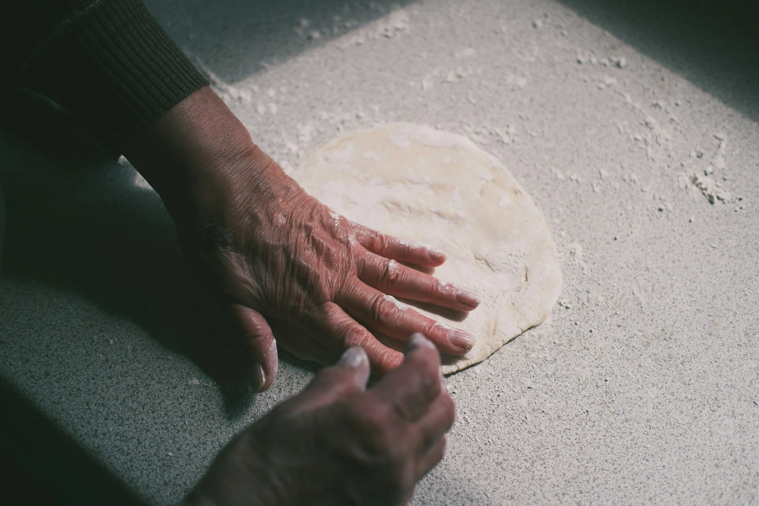 hands on a floured surface kneading dough