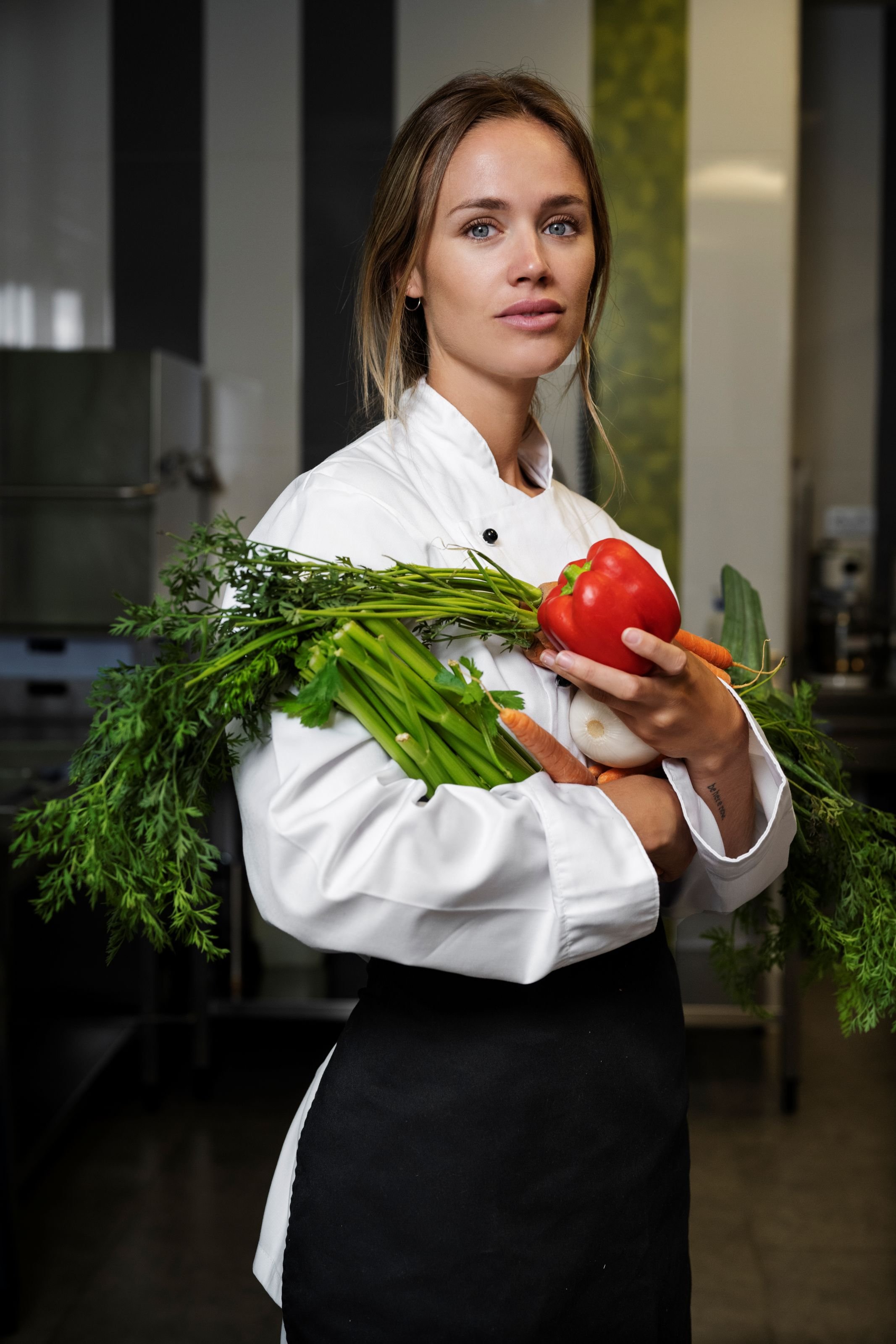 female-chef-kitchen-holding-vegetables.jpg