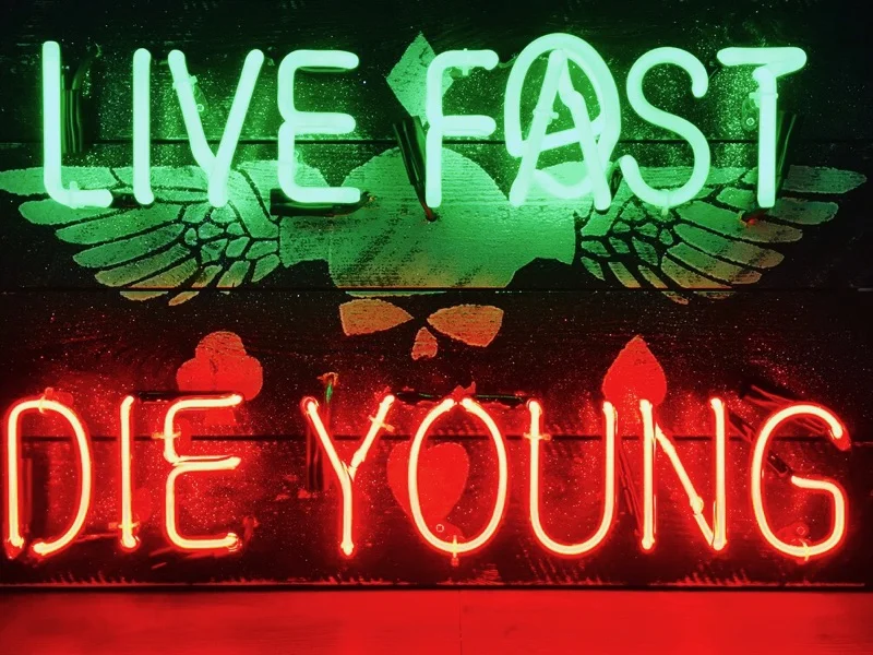 Illuminati Neon Live Fast Die Young , 2017 green & red neon on spray painted distressed board 48.5x76cm