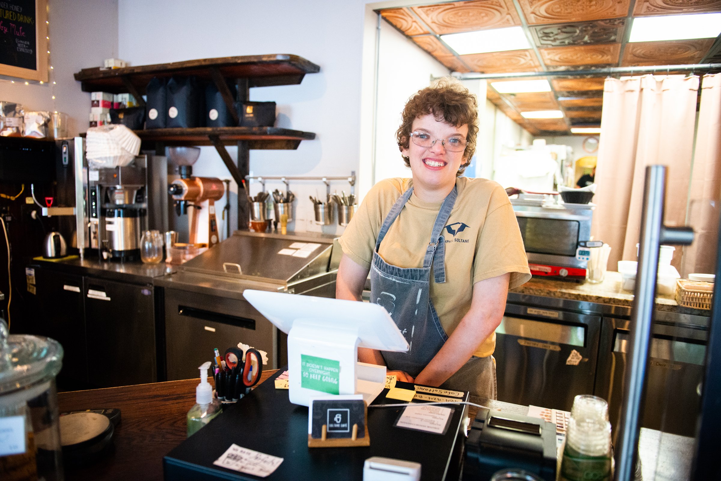 Cashier Kathleen R. working the register and greeting customers at Soltane Café.