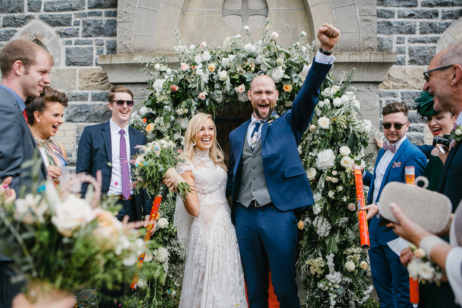 bride and groom by flower arch photo