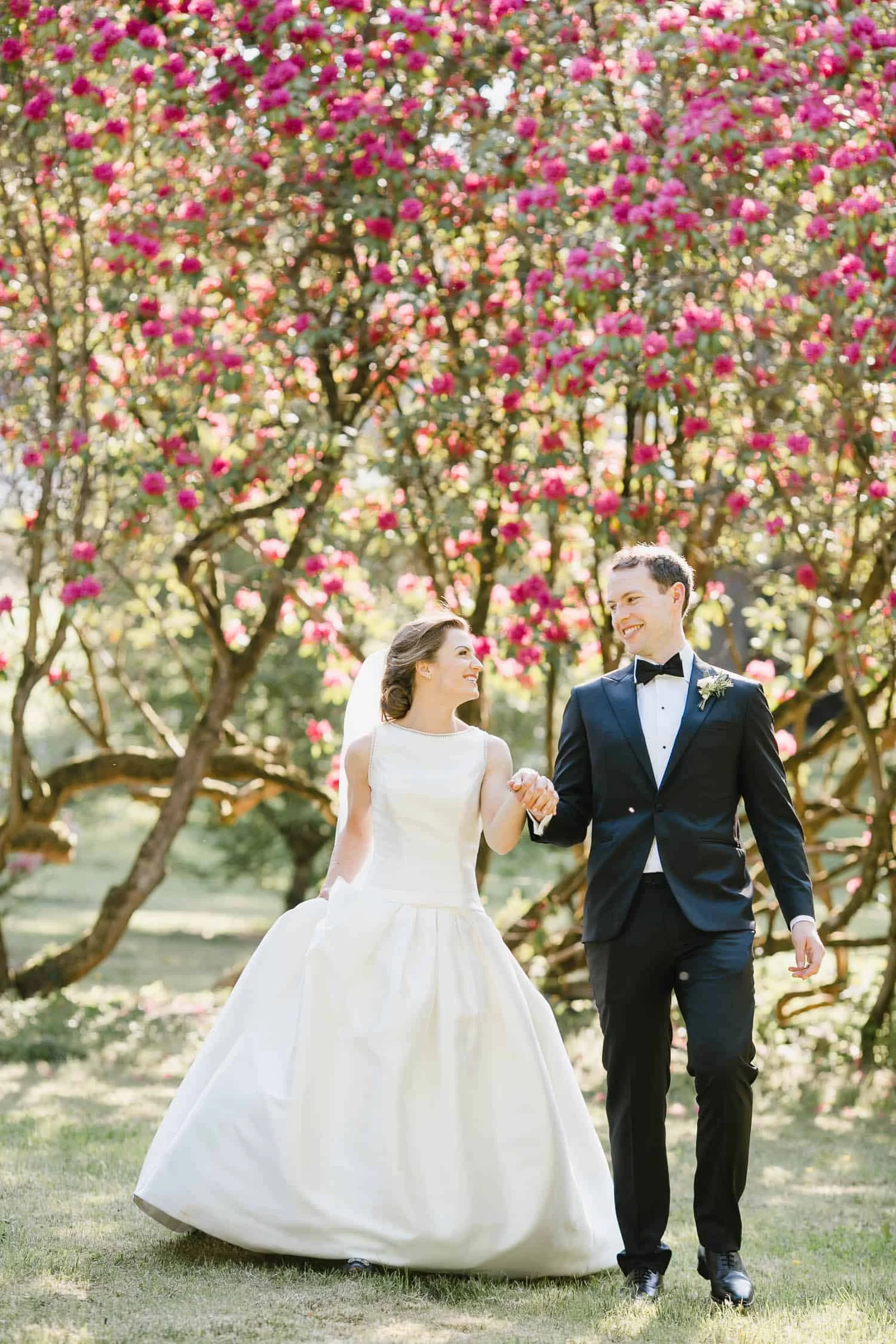 Bride and Groom Hold Hands in the Garden at Virginia Park Lodge