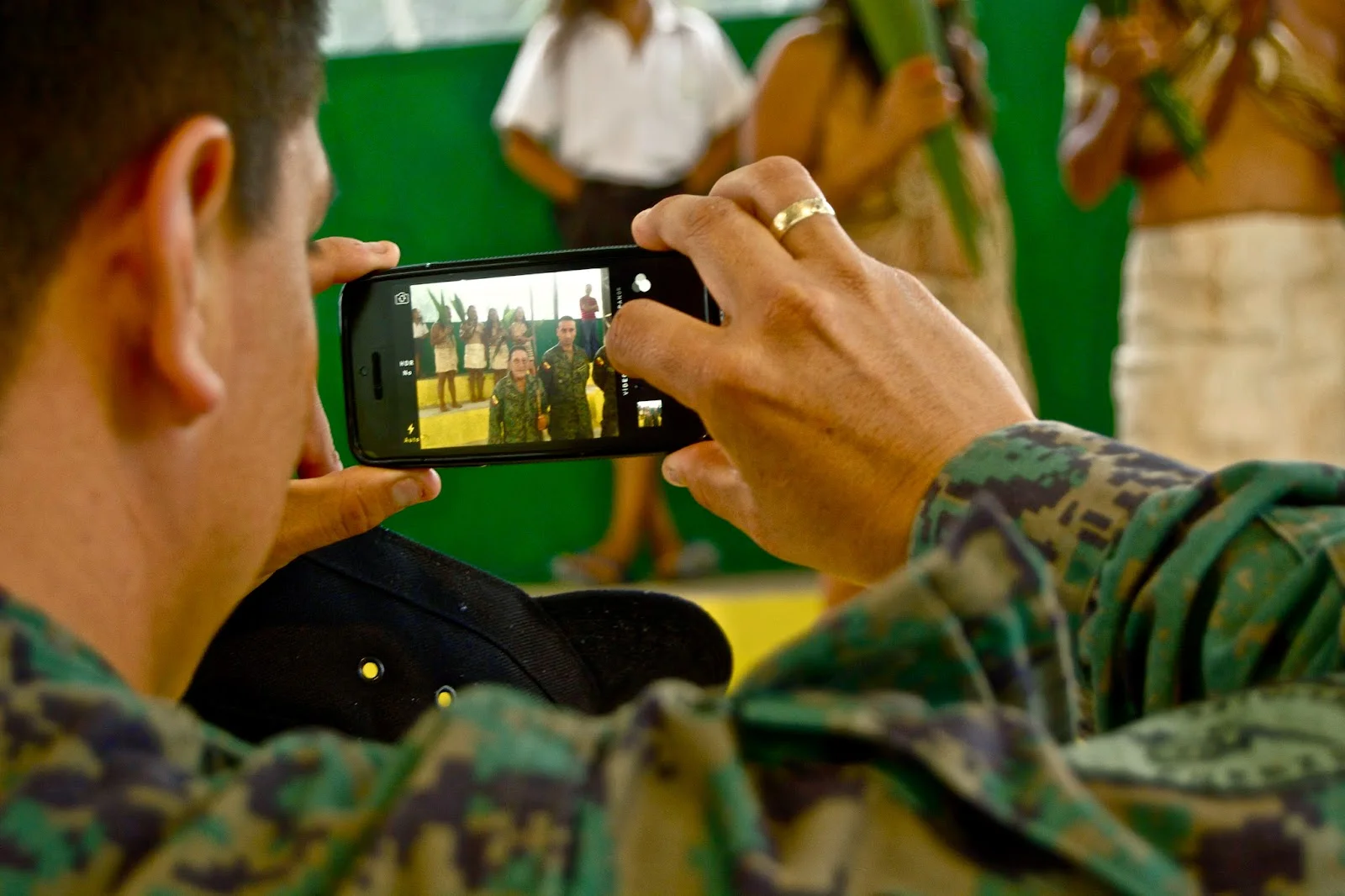 an Ecuadorian soldier takes photos of the Waorani