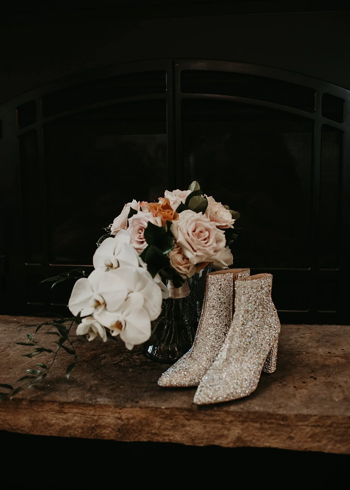 Glittery boots and flower bouquet on stone ledge