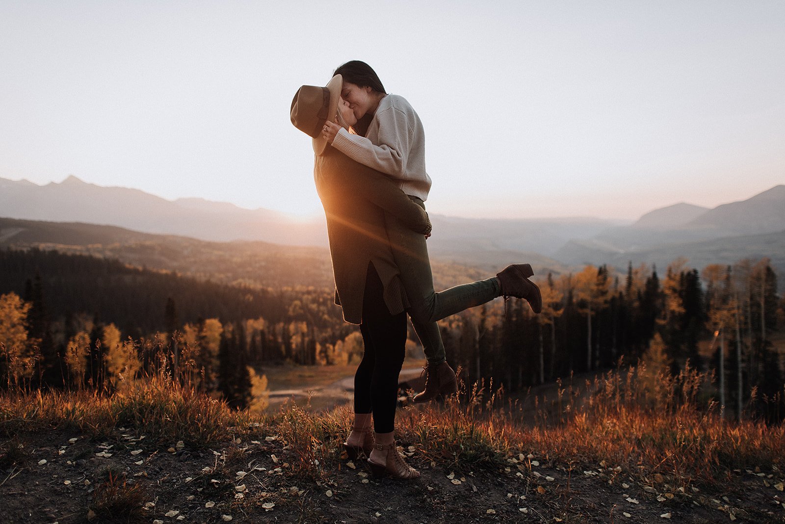Couple embracing outdoors at sunset with mountain view