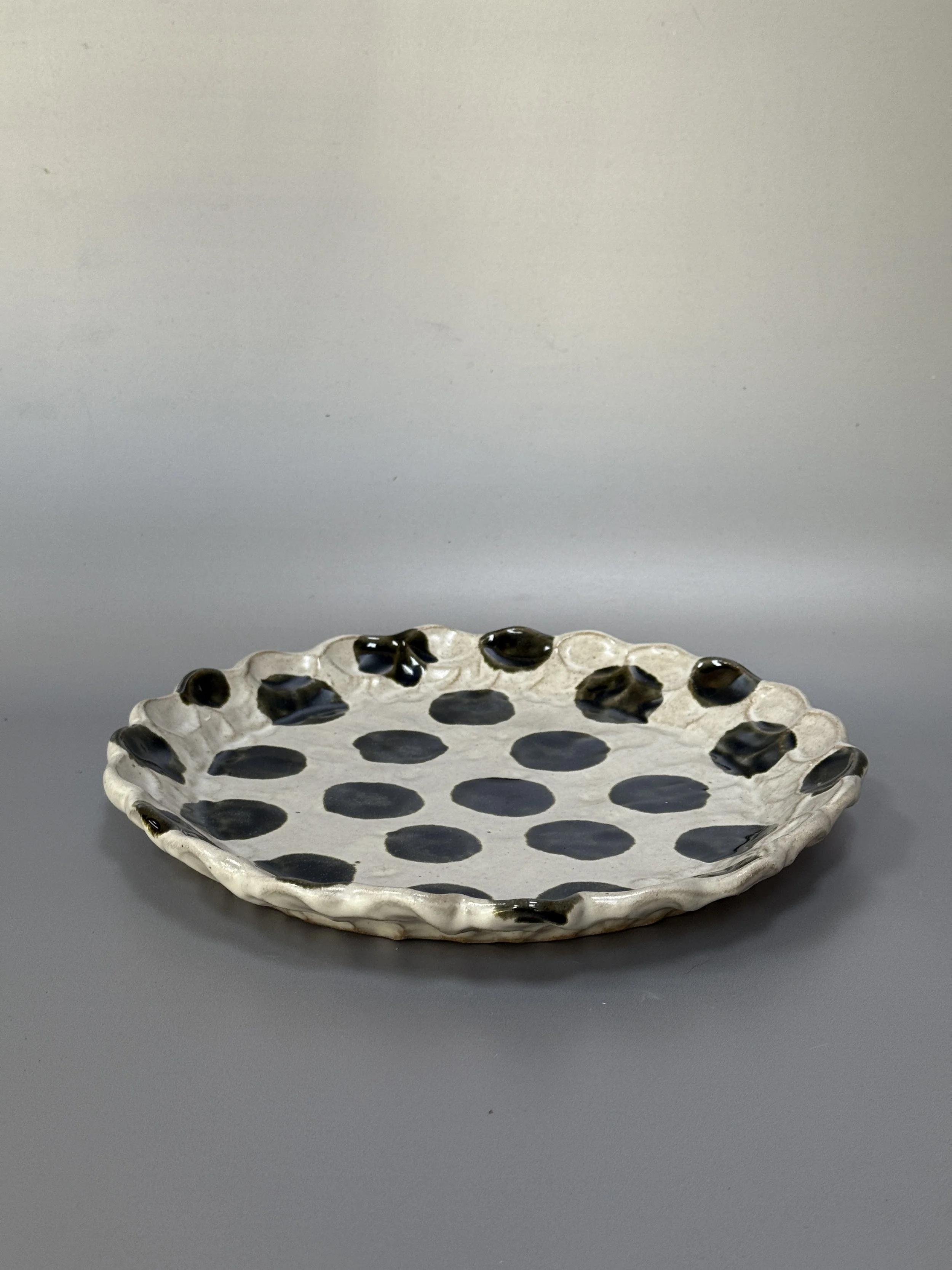 Large round pinched platter (black spots)
