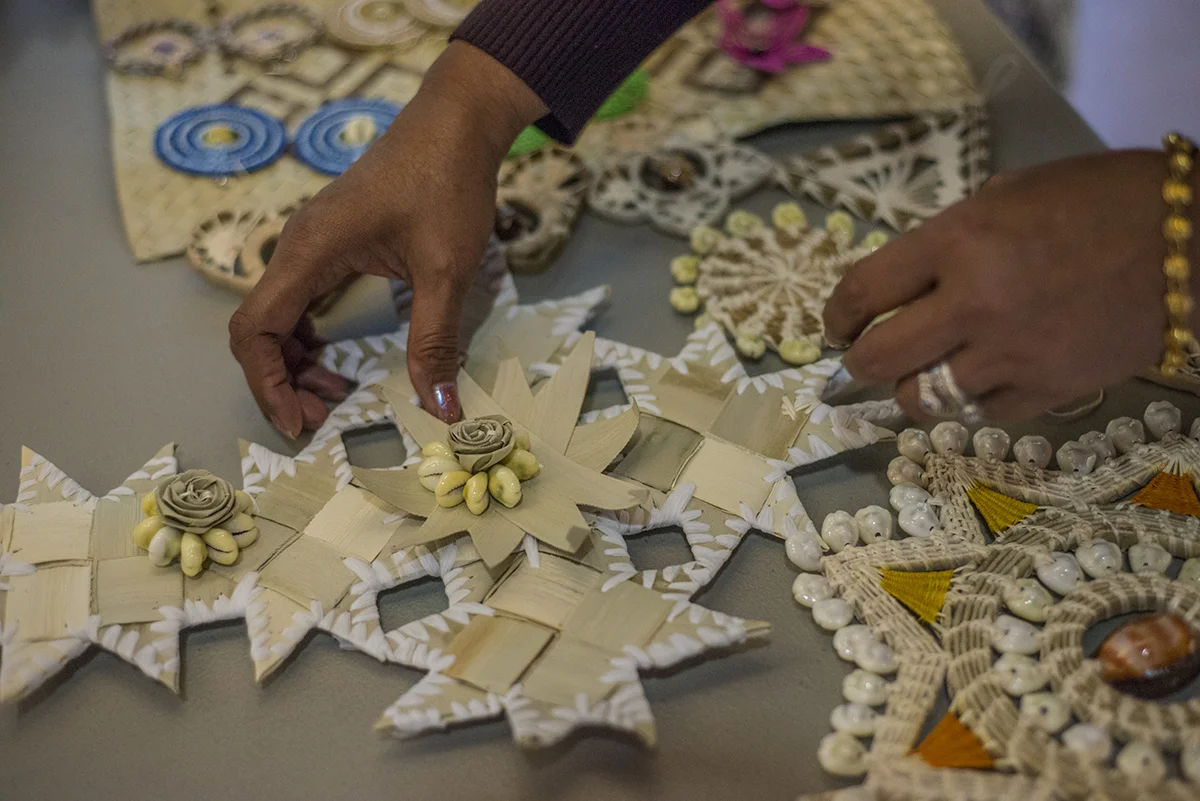 Kianna's sister, Cenna, lays out Marshallese gifts on the table for people to take at the outrigger unveiling event. @Savannah Blake