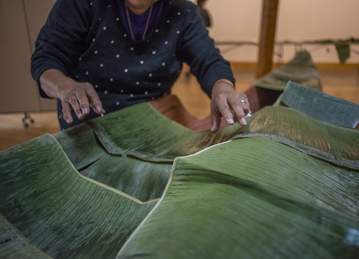 Once "Mama" places the leaves on the outrigger, she pushes them around to make sure there are no exposed areas. @Savannah Blake