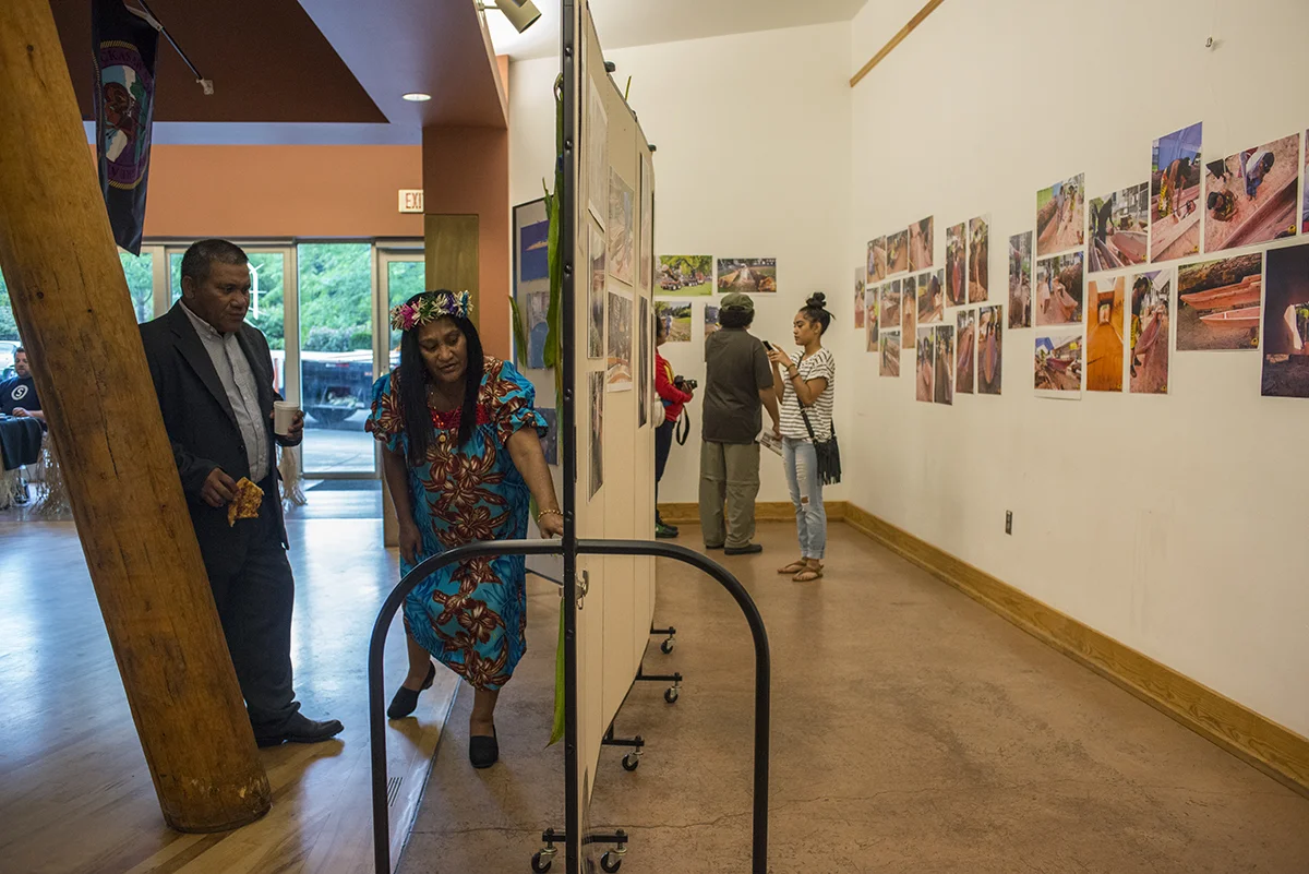 Cenna and her husband look at photos of the Marshall Islands during the outrigger unveiling event at Portland State University. @Savannah Blake