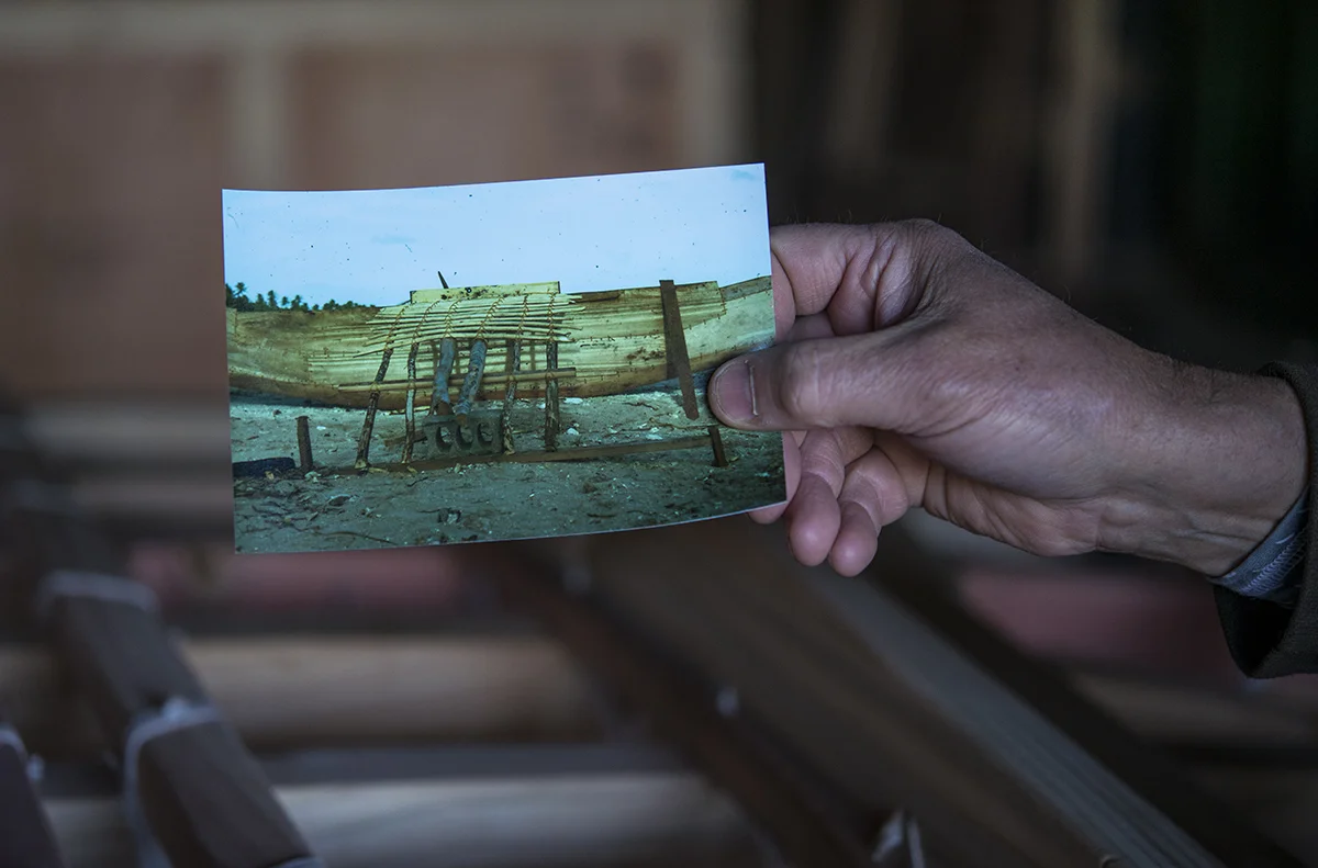 Volunteer David Anderson holds up a picture of a traditional outrigger in the Marshall Islands. He said the outriggers built in the Marshall Islands are not built for beauty, but instead for a purpose. The locals usually piece together driftwood and other sticks found around the island. 