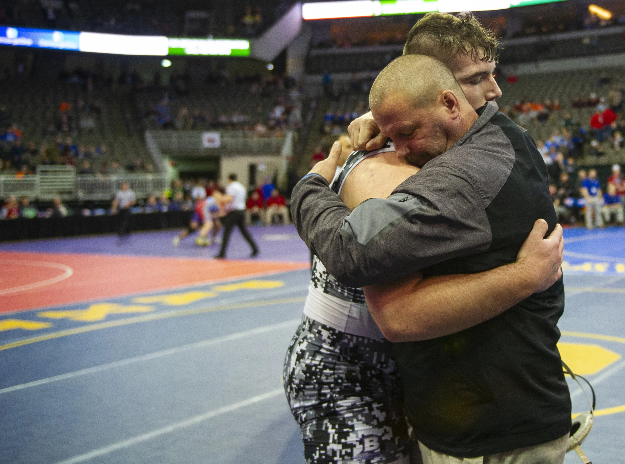OMAHA, NEB. - Filmore Central's Riley Moses hugs head coach Ryan Komenda after winning against Broken Bow's Drew Drake in the Class C 285 match on Friday, Feb. 15, 2019, during the state wrestling semifinals at CHI Health Center.