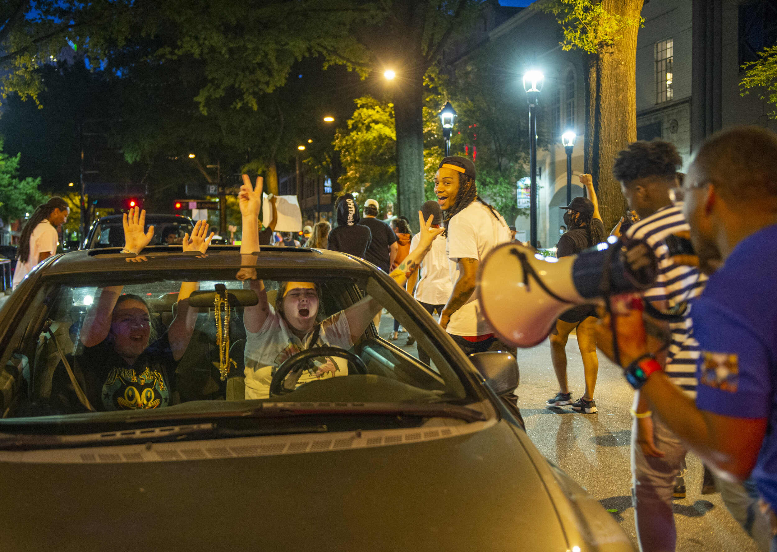 A driver and passenger scream and yell in solidarity with protesters as they marched down Main Street.