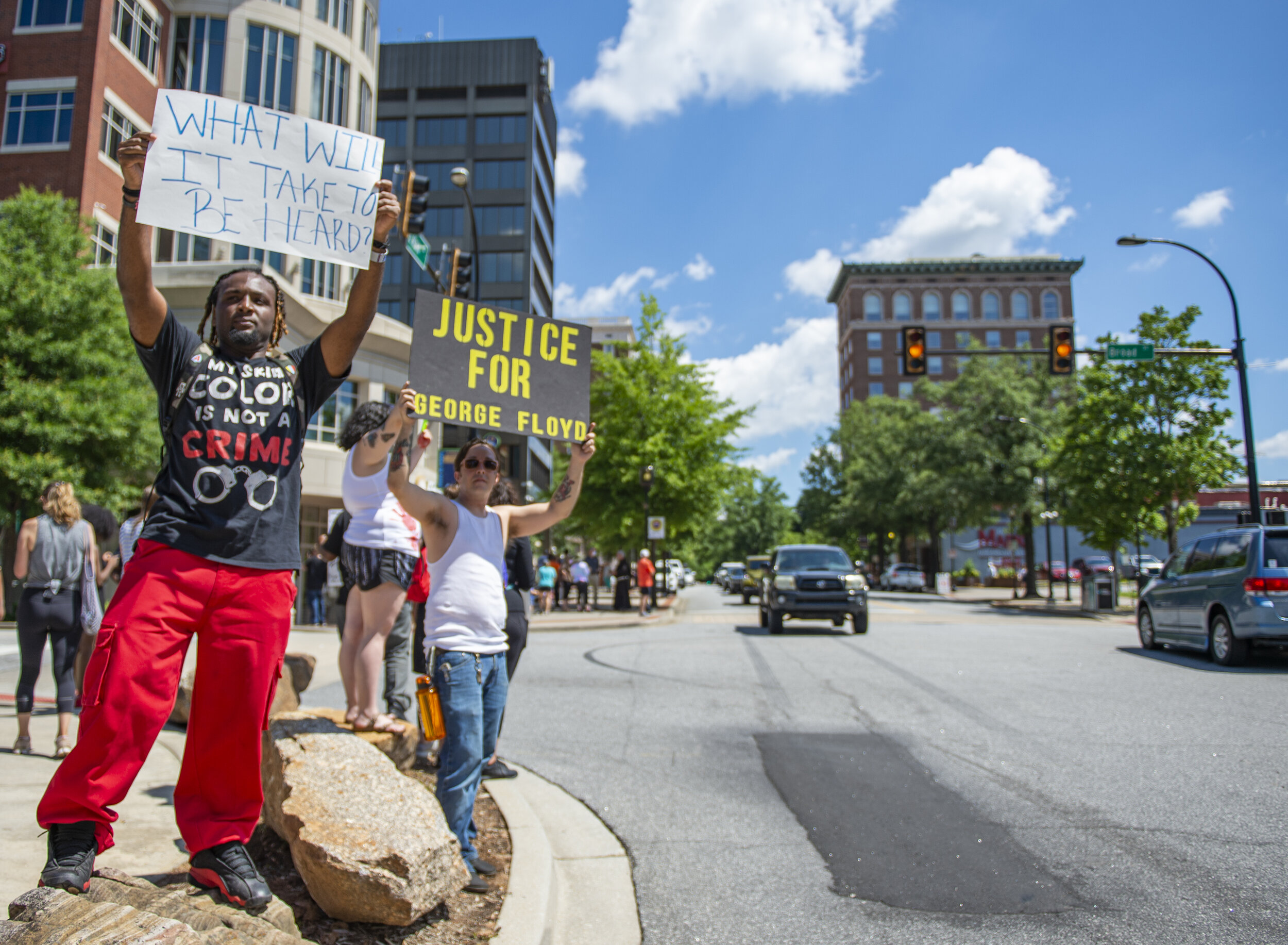 Protester Eric Ranson holds up a sign for passerbys to see on Saturday afternoon at the Peace Center in downtown Greenville.