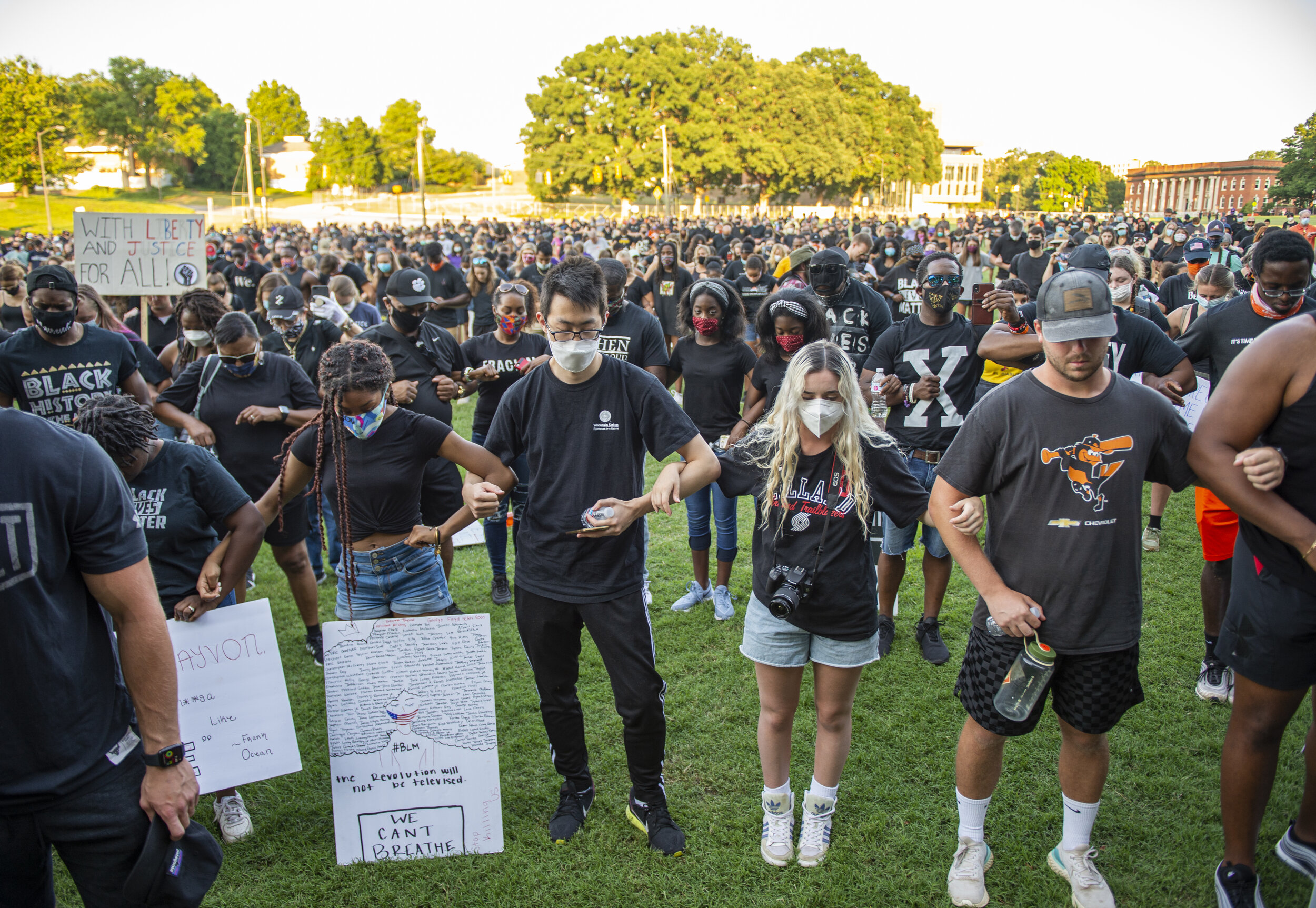 Thousands of protesters link their arms together and bow their head in prayer at the end of Clemson Community Peaceful Protest.