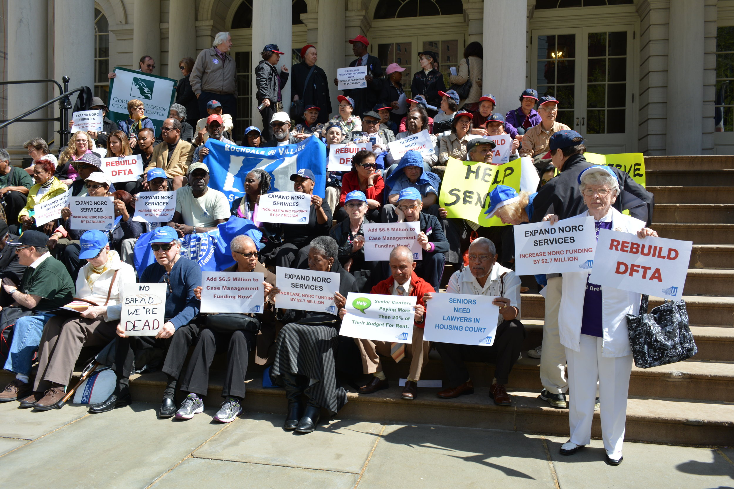 Seniors Hold Signs Calling for Investments in Services