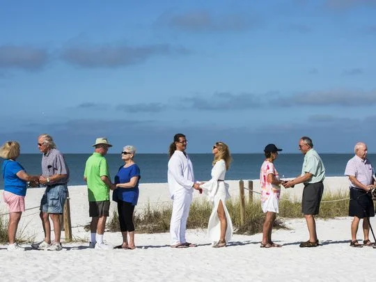 Rev. Heather Desrocher performs a Valentine's Day vow renewal on the sandy beaches of Lovers Key on Wednesday, Feb. 21, 2018.