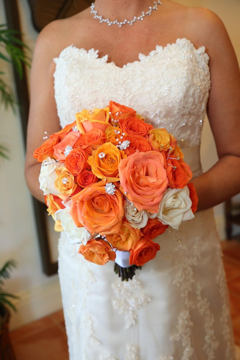 Lush peach and white roses with rhinestone accents for the bride