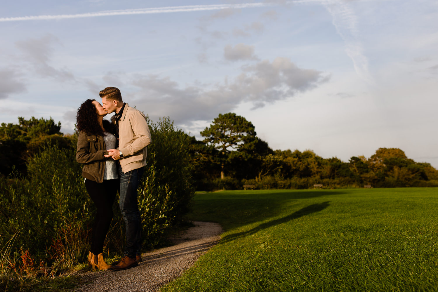 Couple having a kiss on their Wirral Country park pre wedding shoot at sunset