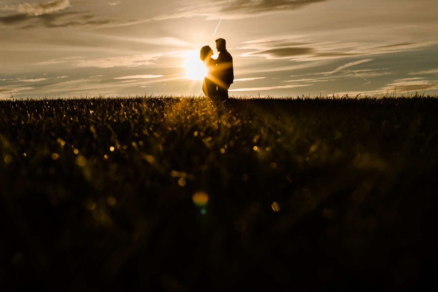 Starburst sunset with silhouette couple on a hill - Merseyside golden hour couple shoot