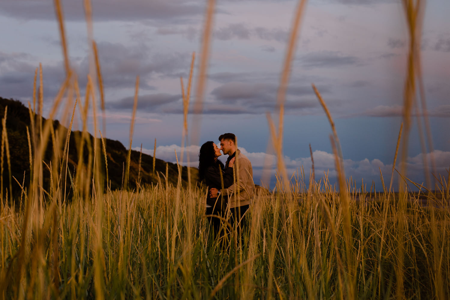Sunset photography - Couple stood in the grass on a beach in Merseyside