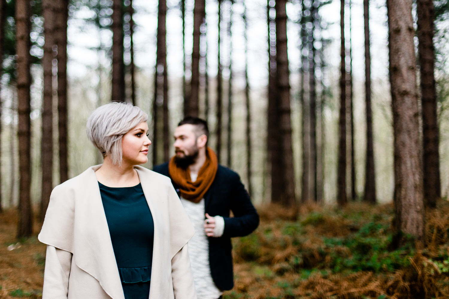 An engaged couple stood among pine trees on their pre wedding shoot in Yorkshire
