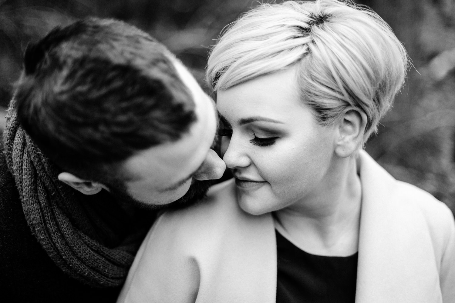 A man and woman almost kissing, on their engagement shoot by a wedding photographer