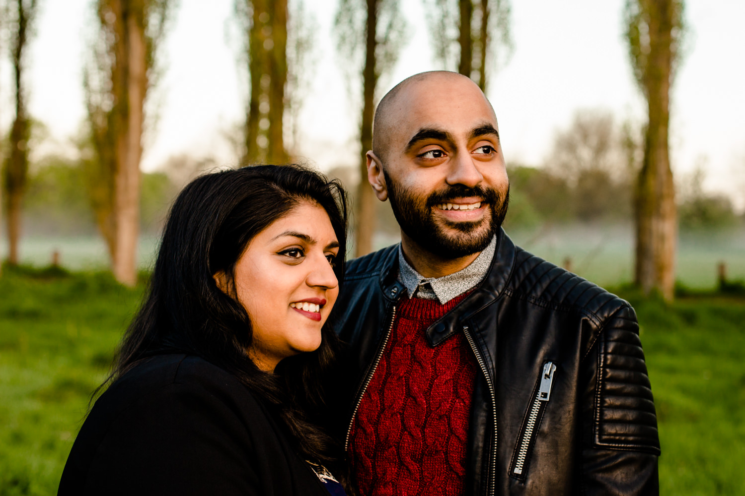Man and woman smiling, watching the sunrise.