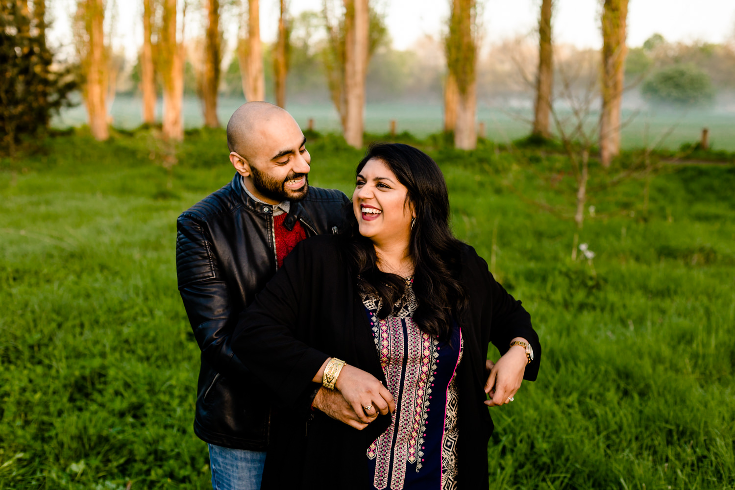 Couple laughing on their Hindu pre wedding shoot in a Manchester park