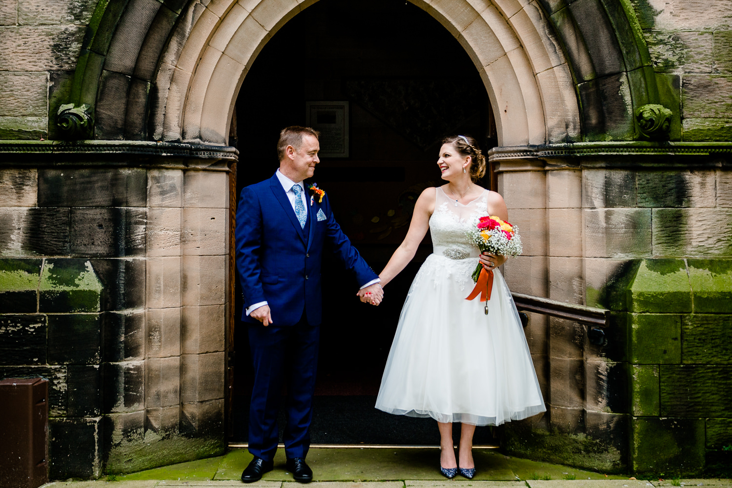 Bride and Groom Kat and Ray outside church after their wedding ceremony in Wirral. 