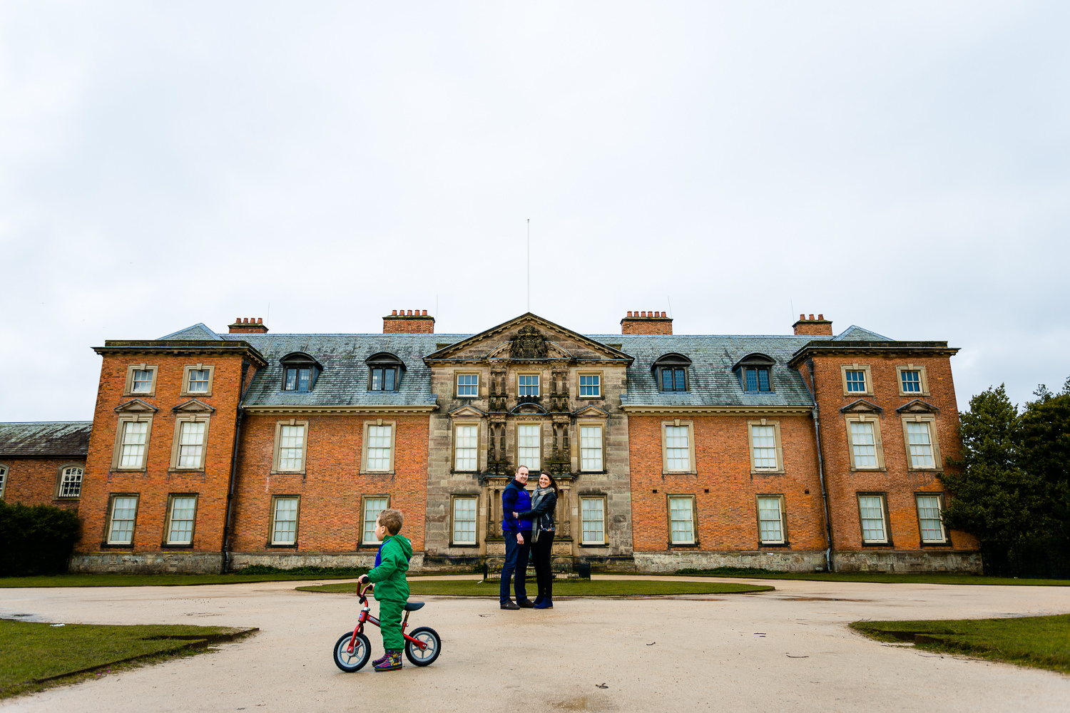 A couple on their pre wedding shoot stood in front of the house at Dunham Massey.