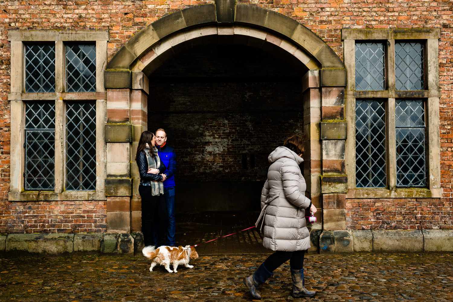 A dog walker passing by a couple at Dunham Massey. 