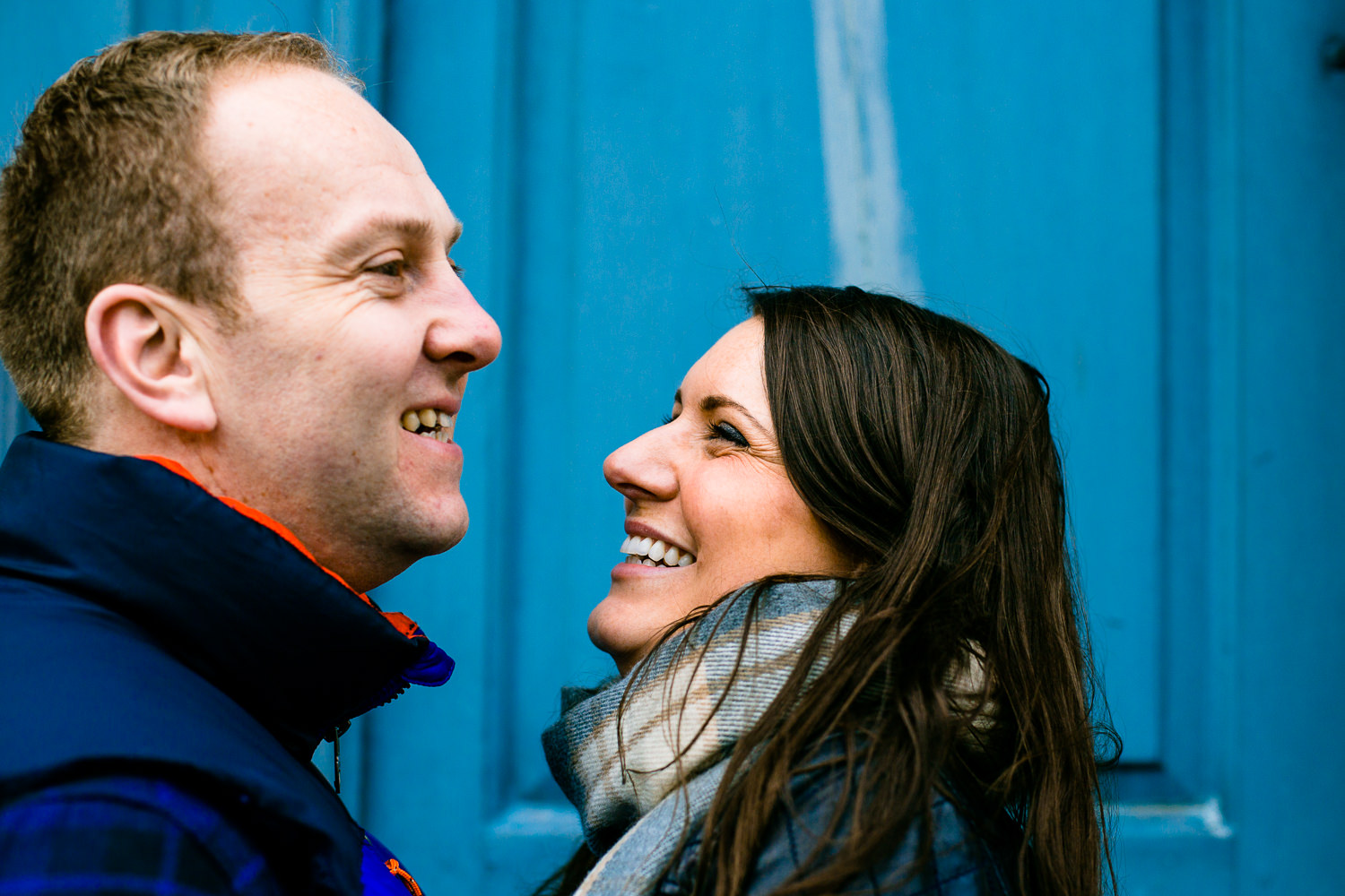 Claire and Damien laugh in front of a blue door at Dunham Massey. 