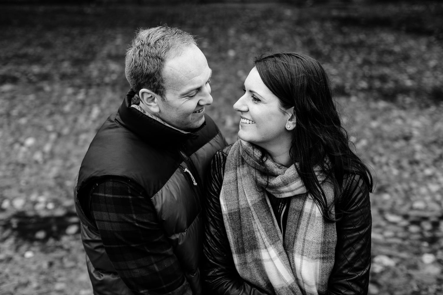 Black and white photo of a couple smiling at each other, Dunham Massey pre wedding shoot.