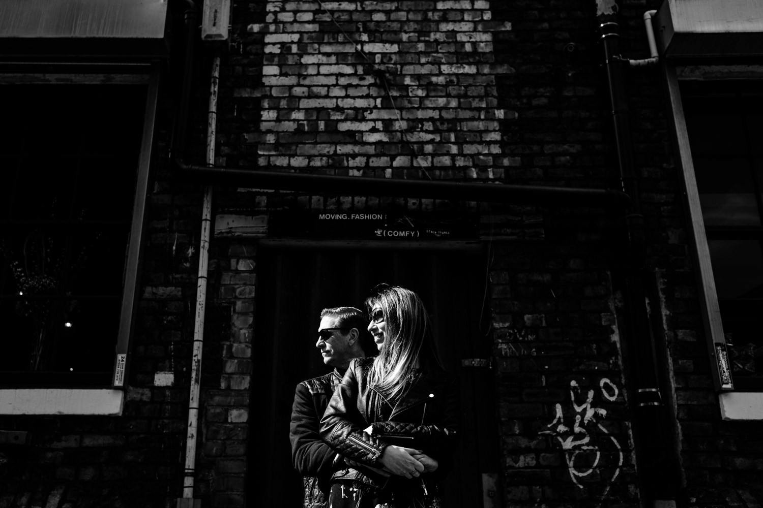 Northern Quarter pre wedding shoot manchester wedding photographers, a couple cuddle in the sunlight