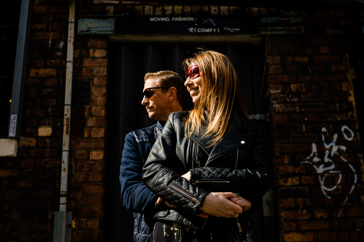 Northern Quarter pre wedding shoot manchester wedding photographers, a couple cuddle in the sunlight