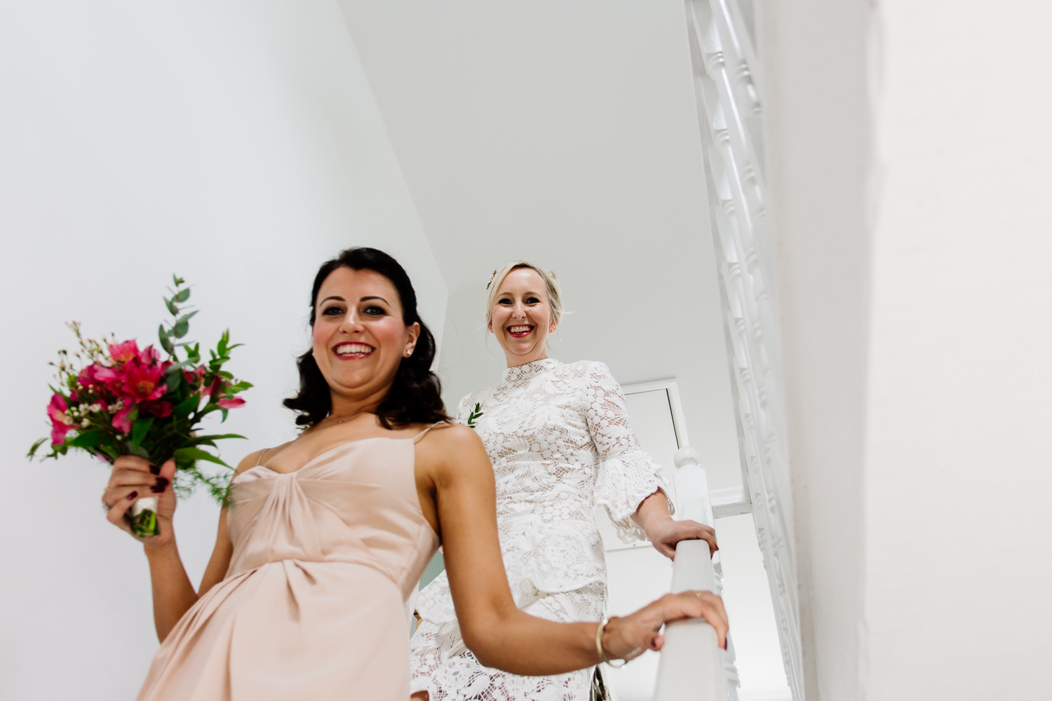 Bride and bridemaid coming down the stairs before a Wales wedding in Anglesey.