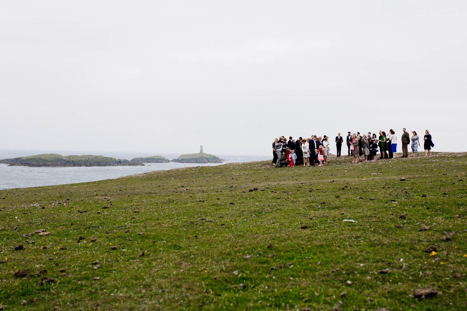 Wedding guests await the bride on the Anglesey headland overlooking the sea for an outdoor ceremony.