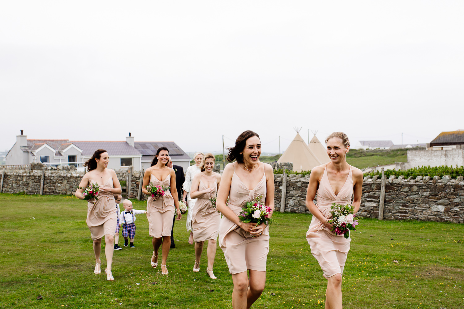 Bridemaids brave the windy headland in Anglesey, wedding photographer Wales.