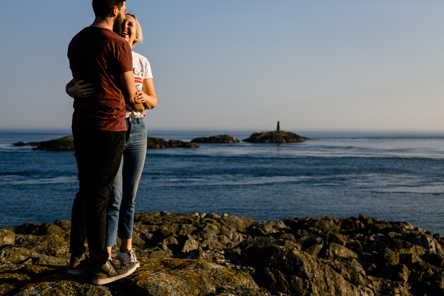 Anglesey pre wedding shoot, a couple stod on the headland looking out to sea.