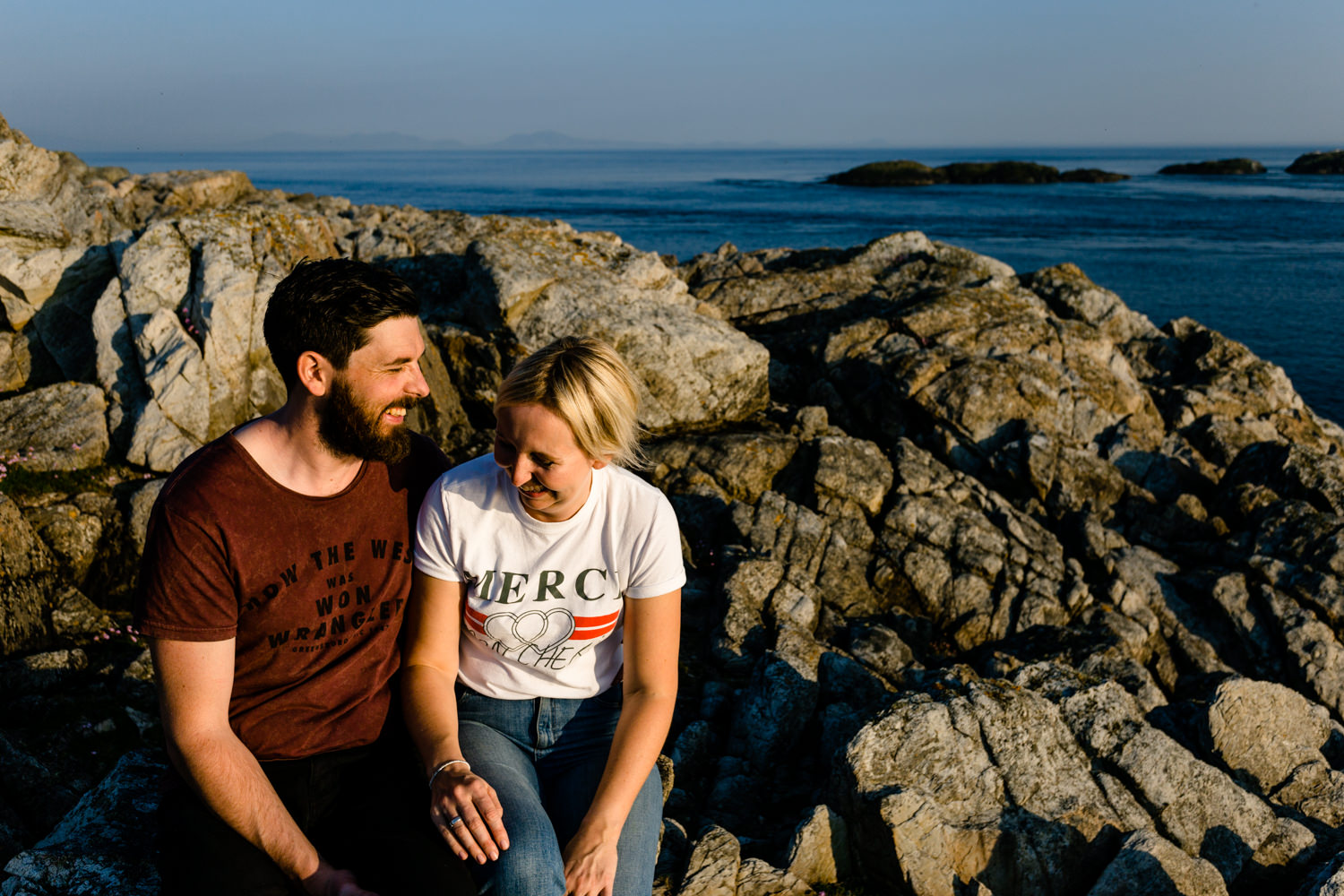 Anglesey Wedding photographers capture a couple laughing together on the headland rocks.