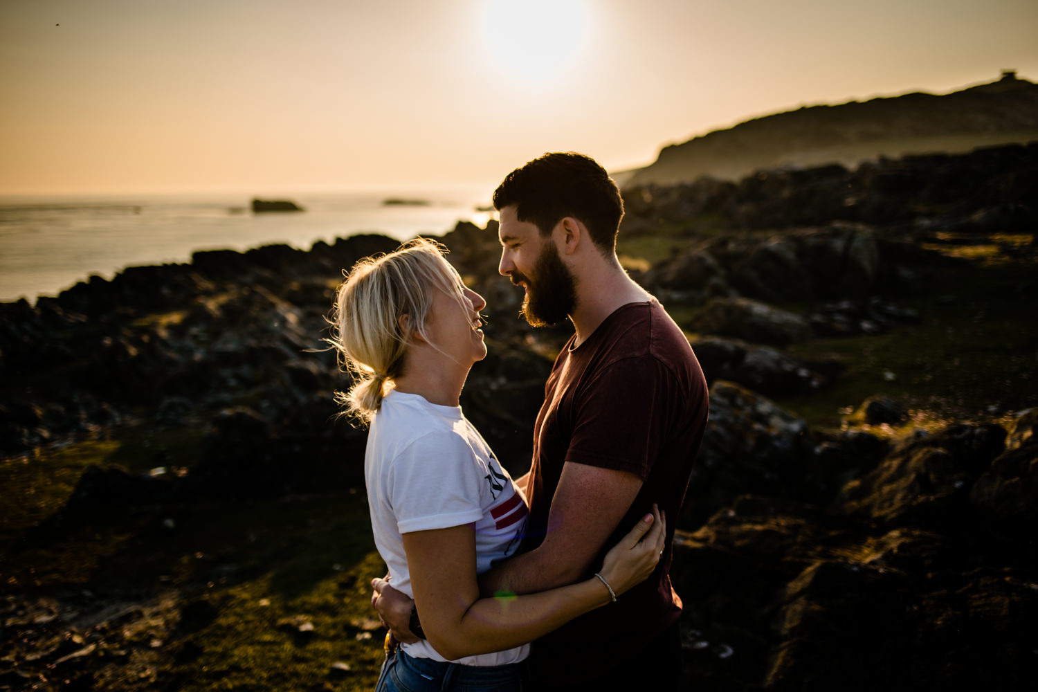 Anglesey pre wedding shoot. A couple facing each other as the sun sets.