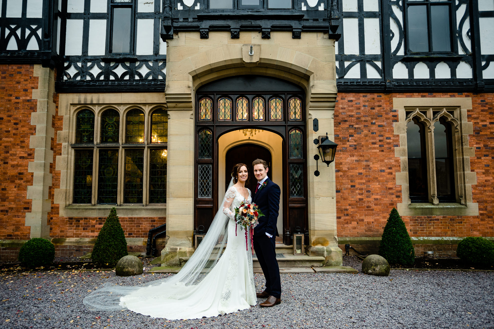 Bride and Groom outside the entrance door to Tyn Dwr Hall a 19th century hall wedding venue in Wales