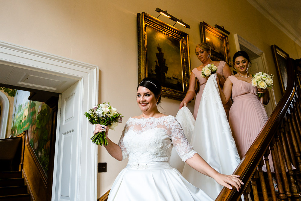 A bride on the stairs at Iscoyd Park ahead of her wedding ceremony